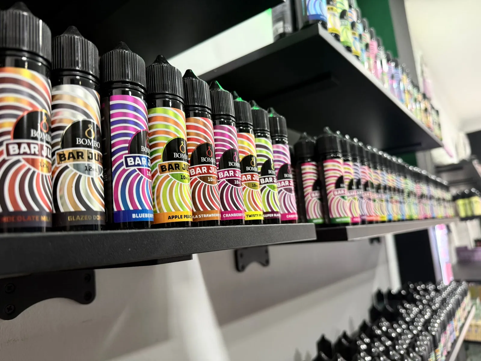 Estanterías de MASVAPE en Málaga llenas de líquidos de muchos colores
