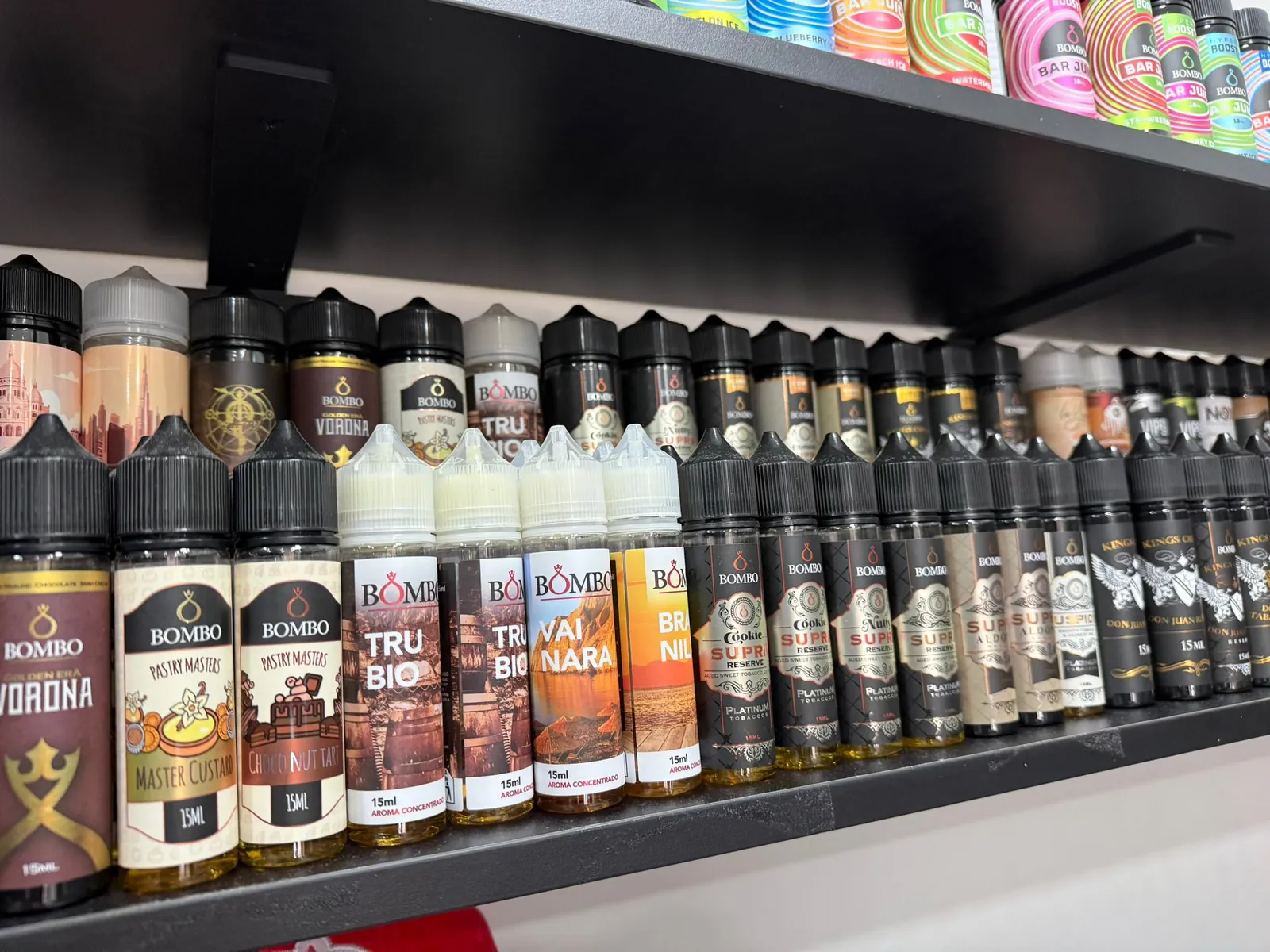 Estantería de MASVAPE con botellas de líquido colocadas en filas por sabores